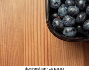 Delicious fresh blueberries in a black container on a wooden table background. close-up. selective focus. free text space. copy space - Shutterstock ID 2234326663