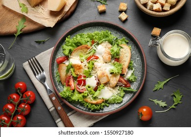 Delicious Fresh Caesar Salad On Black Table, Flat Lay