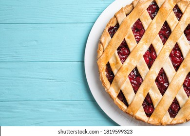 Delicious fresh cherry pie on light blue wooden table, top view. Space for text