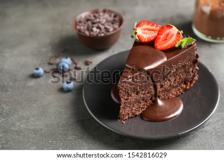 Delicious fresh chocolate cake with strawberry on grey table
