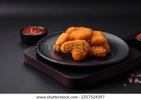 Delicious fresh crispy chicken nuggets on a dark concrete background. Unhealthy food, fast food