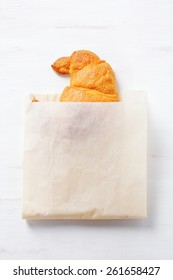 Delicious fresh croissant in paper packaging. Traditional French breakfast