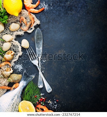 Delicious fresh fish and seafood on dark vintage background. Fish, clams and  shrimps with aromatic herbs, spices and vegetables - healthy food, diet or cooking concept