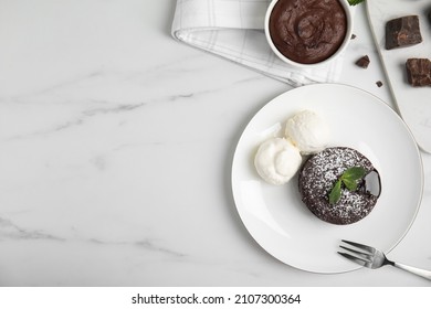Delicious fresh fondant with hot chocolate, mint and ice cream served on white table, flat lay. Space for text