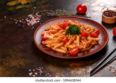 Delicious fresh paste with tomato sauce with spices and herbs on a dark background. Mediterranean cuisine