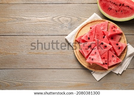 Delicious fresh watermelon slices on wooden table, flat lay. Space for text