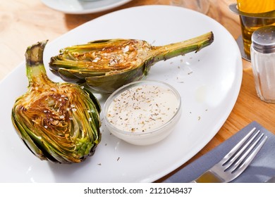 Delicious fried artichoke halves with coarse salt on a white plate. High quality photo - Shutterstock ID 2121048437