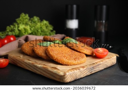 Delicious fried breaded cutlets served on black table