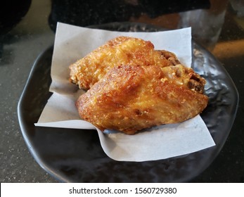 Delicious Fried Chicken Wings On Blotter Paper On Mini Black Dish