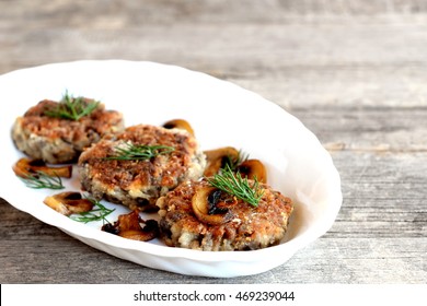 Delicious fried mushroom cutlets on a plate and wooden table. Healthy vegetarian cutlets. Mushroom dish. Homemade food photo  - Powered by Shutterstock