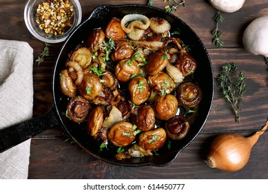 Delicious fried mushrooms in pan on wooden table, top view