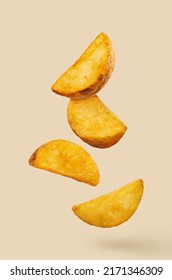 Delicious Fried Potato Wedges, Flying In The Air, Isolated On Pastel Peach Background