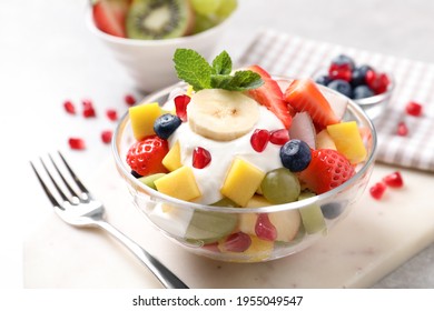 Delicious fruit salad with yogurt on light table