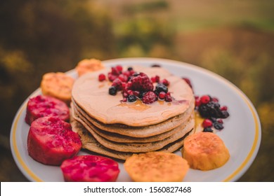 Delicious fruit stack Pancakes with red berries, prickly pear and honey. protein meal 