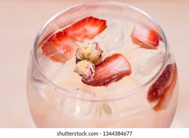 Delicious Gin Tonic cocktail decorated with strawberry and mini roses on a wooden background. Aromatic drink.  - Shutterstock ID 1344384677