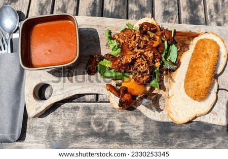 Delicious golden brown croquette, a hot chicken sandwich and a tomato soup are served in a restaurant as luch as a twelve o'clock, also called a twaalf uurtje in the Dutch language in the Netherlands.