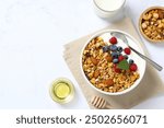 Delicious granola with berries and yogurt on a light background