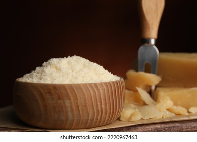 Delicious Grated Parmesan Cheese In Bowl On Wooden Table