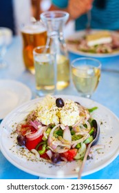 Délicieuse salade grecque avec des légumes frais et fromage de chèvre grec feta servi au restaurant avec du vin blanc