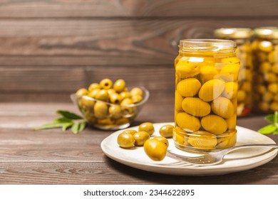 Delicious green olives. Pickled olives in glass jar. On a wooden background.Tasty olives. Close-up. Vegan.Place for text. copy space. - Powered by Shutterstock