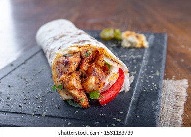 Delicious Grilled Chicken Kebab Wrap With Onion Tomato And Parsley On Black Stone Plate.