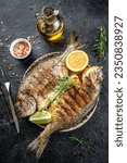 delicious grilled dorado or sea bream fish with lemon. vertical image. top view. place for text.