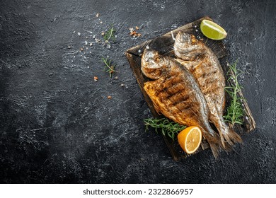 delicious grilled dorado or sea bream fish with lemon. banner, menu, recipe place for text, top view.