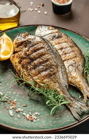 delicious grilled dorado or sea bream fish with lemon. vertical image. top view. place for text.