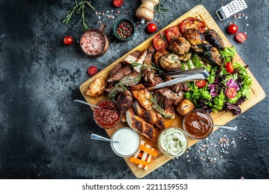 delicious grilled meat with vegetable. Mixed grilled bbq meat with vegetables on wooden platter. Restaurant menu, dieting, cookbook recipe top view,