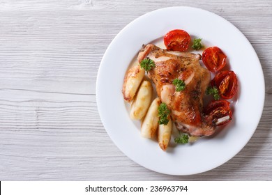 Delicious Grilled Rabbit Leg With Apples And Tomatoes On White Plate Close-up. Horizontal View From Above 