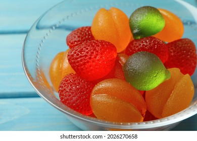 Delicious Gummy Fruit Shaped Candies In Glass Bowl On Light Blue Table, Closeup