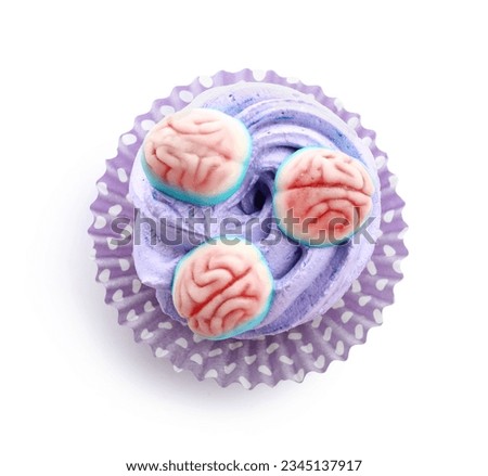 Delicious Halloween cupcake with candies on white background