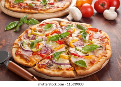 delicious ham, salami,  mushroom and vegetable pizza on a cutting board