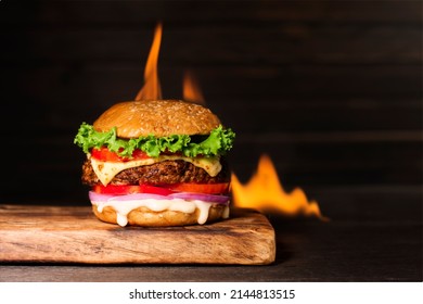 Delicious Hamburger Burger With Flame On A Dark Background