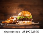 Delicious hamburger placed on a wooden cutting board Along with thick french fries.