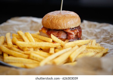 Delicious Hamburger With Tomato Ketchup Sauce Served On Plate With Golden French Fries In Fast Food Cafe Menu.Restaurant Dinner Food Close Up.Roasted Hand Crafted Burger