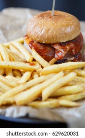 Delicious Hamburger With Tomato Ketchup Sauce Served On Plate With Golden French Fries In Fast Food Cafe Menu.Restaurant Dinner Food Close Up.Roasted Hand Crafted Burger