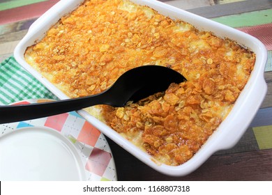 Delicious Hash Brown Casserole With The Butter Cereals On The Top And Melted Cheese In The White Dish With The Colorful Plate And A Colorful Background Ready For A Family Dinner