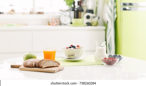 Delicious healthy breakfast at home with cereals, milk and fresh fruit; kitchen interior on the background - Shutterstock ID 738260284