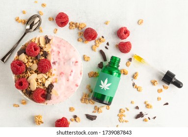 Delicious And Healthy CBD Cannabis Smoothie Bowl Made With Raspberries, Granola, Chocolate And Yogurt. Topped With A Cannabis Leaf And Infused With Marijuana Tincture For A Relaxing Breakfast Or Lunch