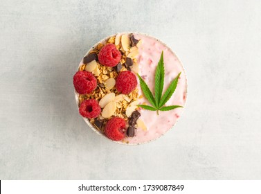 Delicious And Healthy CBD Cannabis Smoothie Bowl Made With Raspberries, Granola, Chocolate And Yogurt. Topped With A Cannabis Leaf And Infused With Marijuana Tincture For A Relaxing Breakfast Or Lunch