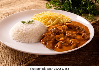 Delicious healthy food with meat strogonoff with rice and french fries on dish. 
