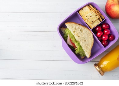 Delicious Healthy Sandwich In A Lunch Box, Cookies And Cherries. Take Lunch With You To School Or The Office, Juice In A Bottle And An Apple