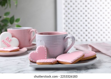 Delicious heart shaped cookies and cup of hot drink on white marble table - Powered by Shutterstock