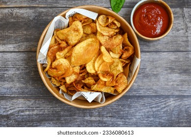 Delicious home made potato chips with sea salt and black pepper against a rustic background. Delicious snack served with sauce. Fast food.Beer snacks - Shutterstock ID 2336080613