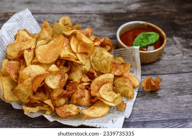 Delicious home made potato chips with sea salt and black pepper against a rustic background. Delicious snack served with sauce. Fast food.Beer snacks - Shutterstock ID 2339735335