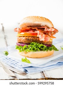 Delicious Home-made Bacon Burger On White Wooden Background