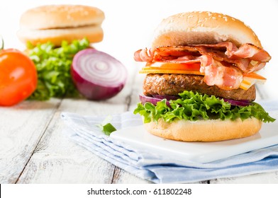 Delicious Home-made Bacon Burger On White Wooden Background