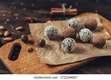 Delicious homemade energy balls with dried apricots, dates, prunes, walnuts, almonds and cashews in sesame seeds and cocoa. Vegan and vegetarian raw appetizer or food. Close-up, copy of the space. - Shutterstock ID 1712244067