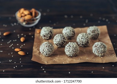 Delicious homemade energy balls with dried apricots, dates, prunes, walnuts, almonds and cashews in sesame. Vegan and vegetarian raw appetizer or food. Top view on a dark wood background. Copy space - Shutterstock ID 1712247700